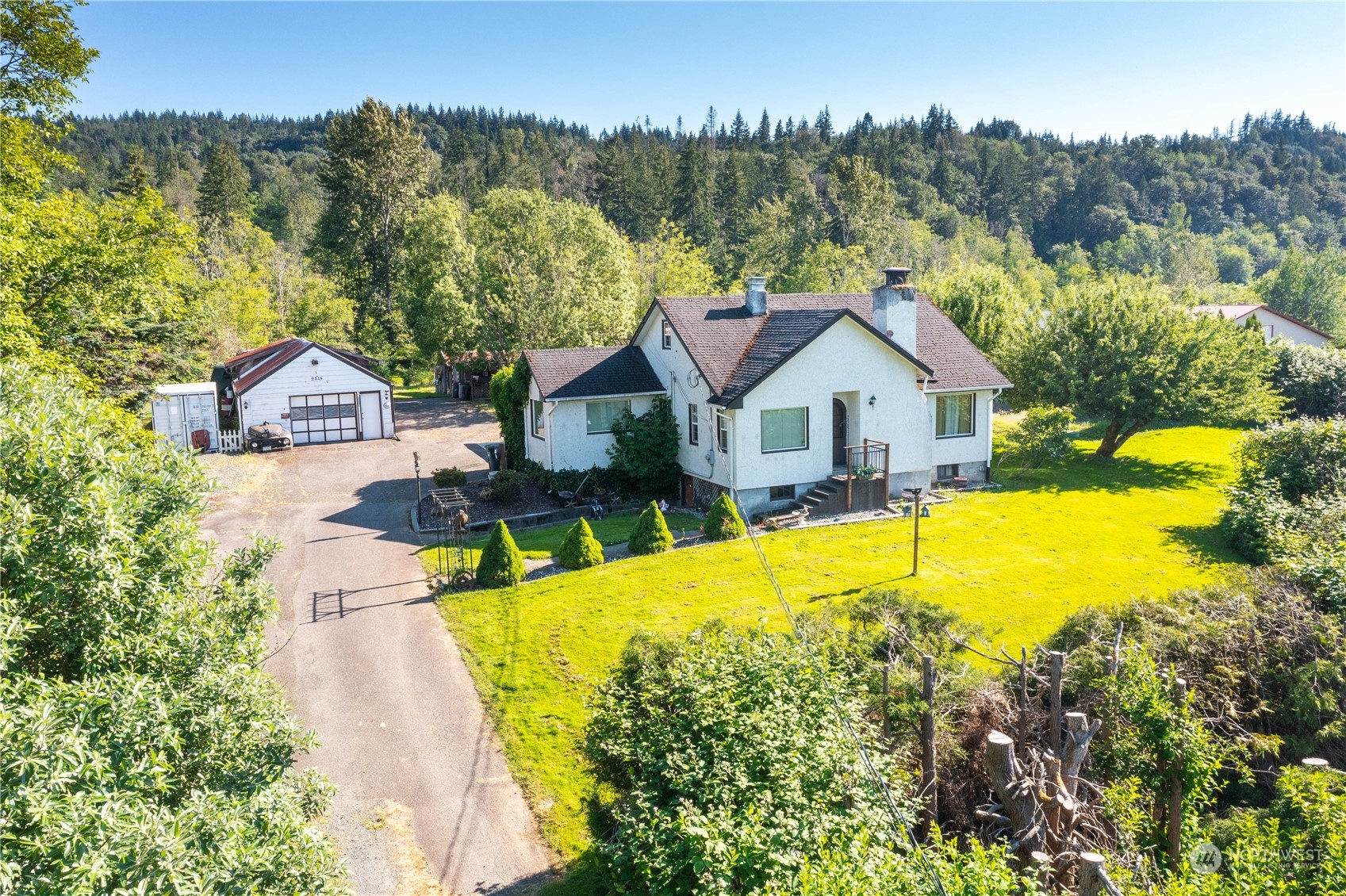 a view of a house with a big yard and large trees
