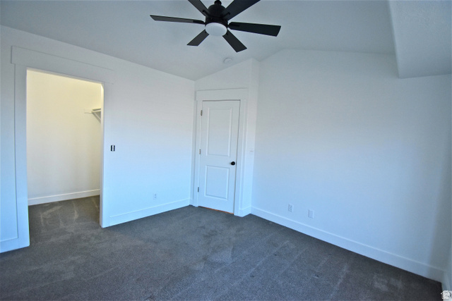 2480 West 450 South, Unit 2 Springville, UT 84663 - Photo 11 of 19 Unfurnished bedroom with dark carpet, a spacious closet, lofted ceiling, and a ceiling fan