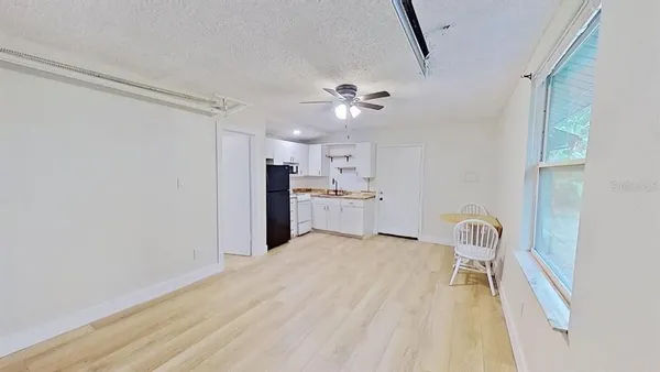 a view of a kitchen with wooden floor and a refrigerator