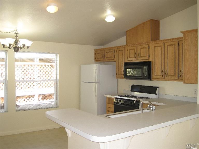 47 Yosemite Road, Unit 47 San Rafael, CA 94903 - Photo 1 of 1 a kitchen with stainless steel appliances a stove a microwave a sink and white cabinets