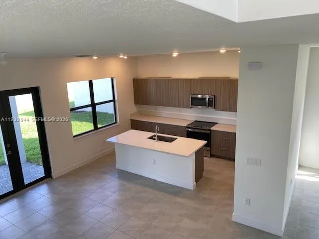 a view of kitchen with stainless steel appliances granite countertop a stove and a sink
