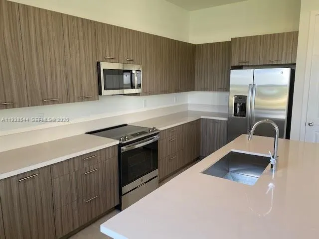 a kitchen with stainless steel appliances granite countertop a sink and a stove top oven