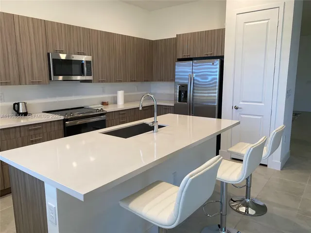a kitchen with a table chairs microwave and cabinets