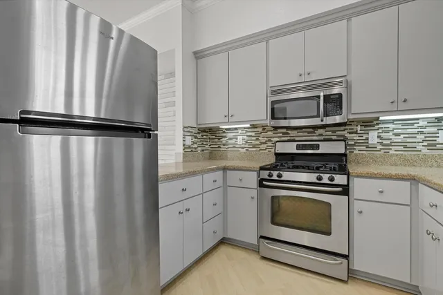 a kitchen with white cabinets sink and stainless steel appliances