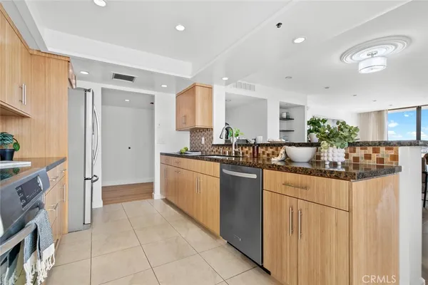 a kitchen with stainless steel appliances granite countertop a stove top oven microwave and refrigerator