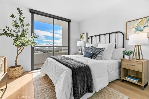 a bedroom with a bed and a potted plant