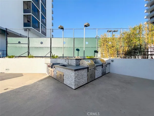 a roof deck with table and chairs and potted plants