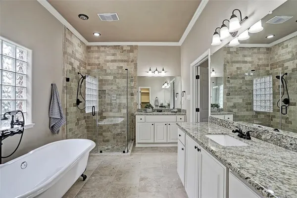 a bathroom with a granite countertop double vanity sink a mirror and a bathtub