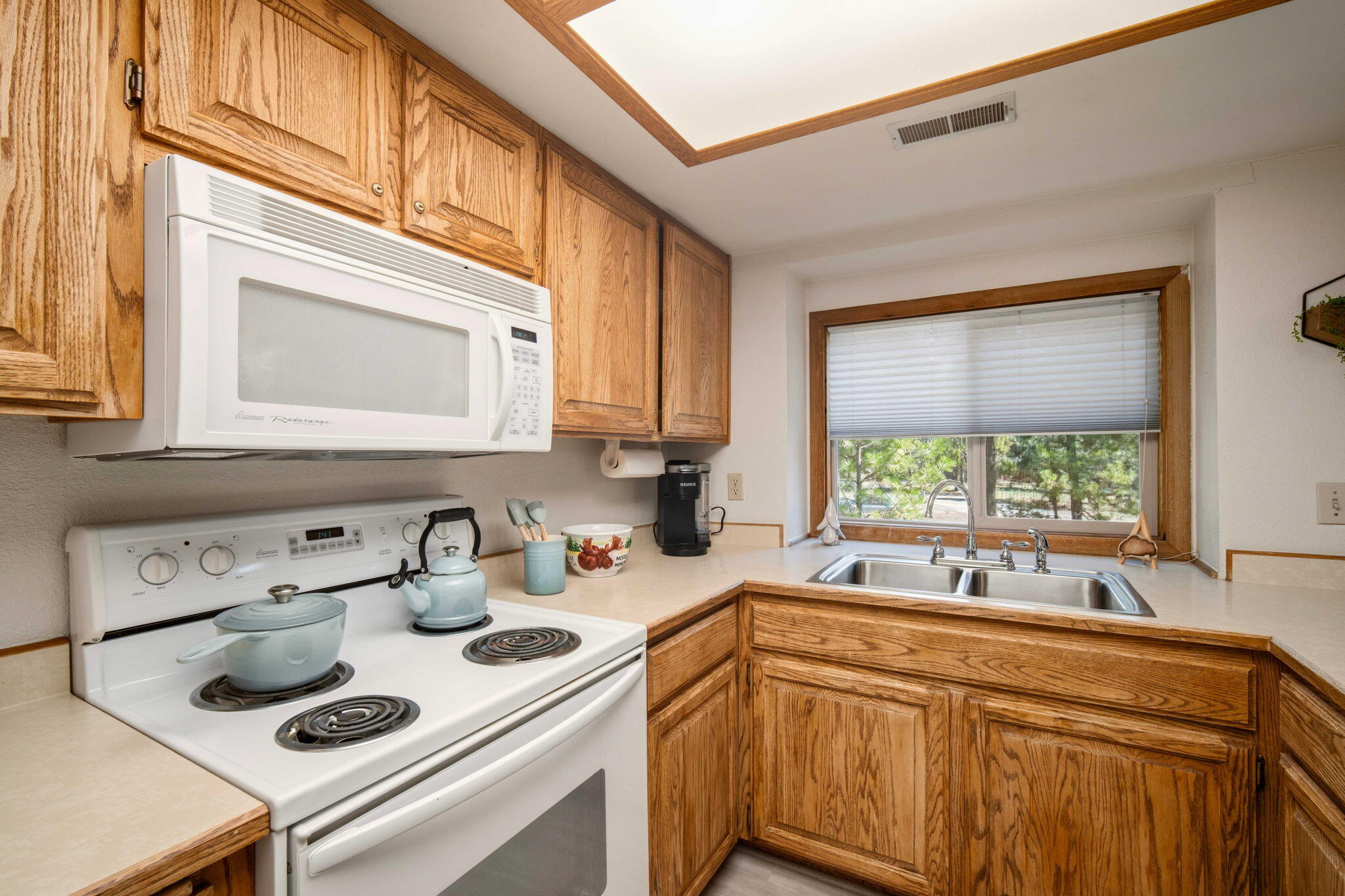 57305 Beaver Ridge Loop, Unit 8 Sunriver, OR 97707 - Photo 10 of 25 a kitchen with a sink cabinets and a window