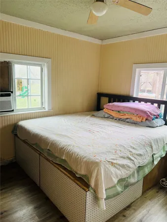 a bedroom with a bed and wooden floor