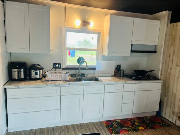 a kitchen with stainless steel appliances a sink a stove and white cabinets