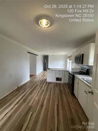 a kitchen with kitchen island granite countertop white cabinets and stainless steel appliances