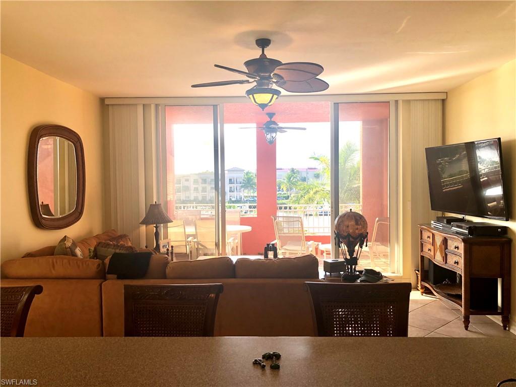 451 Bayfront Place, Unit 5311 Naples, FL 34102 - Photo 16 of 38 a living room with furniture a flat screen tv and a large window