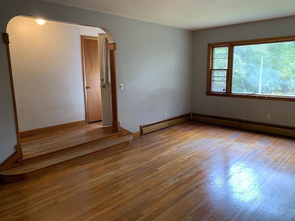 12 Pine Avenue Randolph, MA 02368 - Photo 4 of 18 an empty room with wooden floor and windows