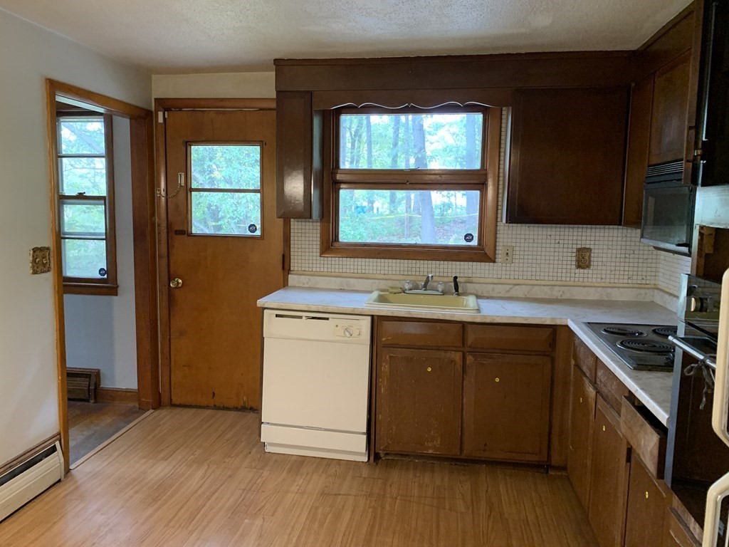 12 Pine Avenue Randolph, MA 02368 - Photo 7 of 18 a kitchen with granite countertop wooden floors and sink