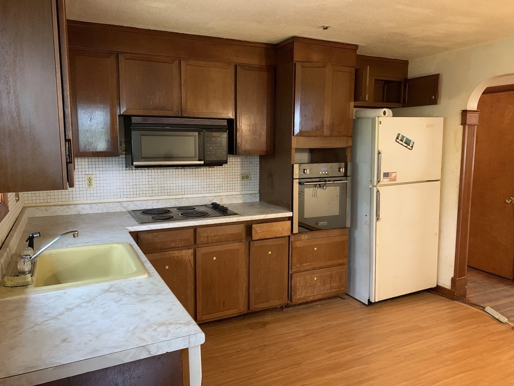 12 Pine Avenue Randolph, MA 02368 - Photo 8 of 18 a kitchen with granite countertop a refrigerator stove and microwave