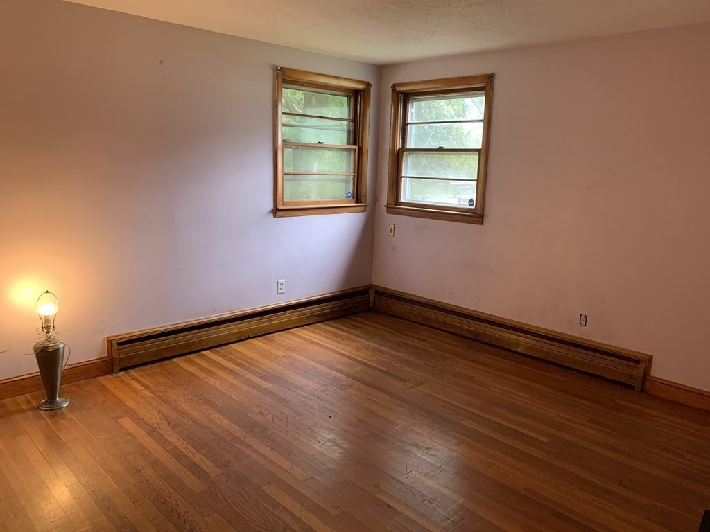 12 Pine Avenue Randolph, MA 02368 - Photo 9 of 18 an empty room with wooden floor and windows