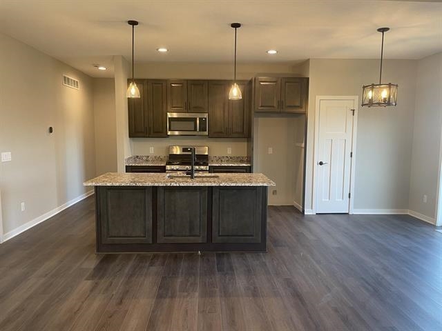 14168 Prairie Commons Lane South Beloit, IL 61080 - Photo 4 of 15 a kitchen with kitchen island a sink stainless steel appliances and cabinets
