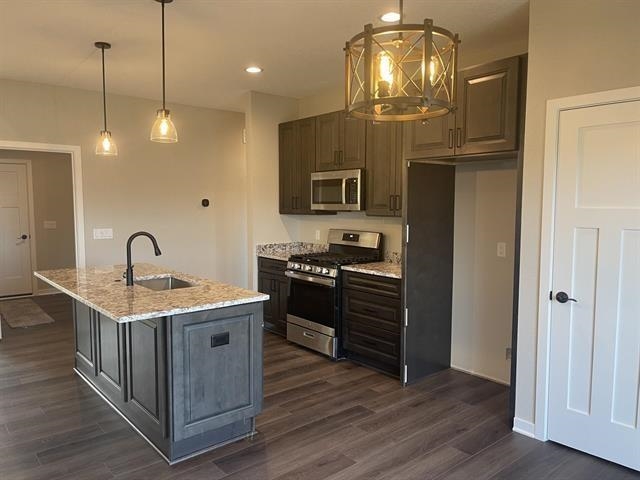 14168 Prairie Commons Lane South Beloit, IL 61080 - Photo 7 of 15 a kitchen with stainless steel appliances granite countertop a stove and a wooden floors