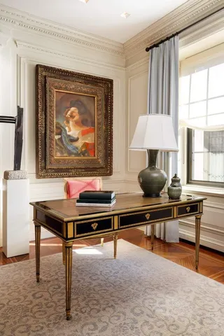 a living room with furniture a desk and a potted plant