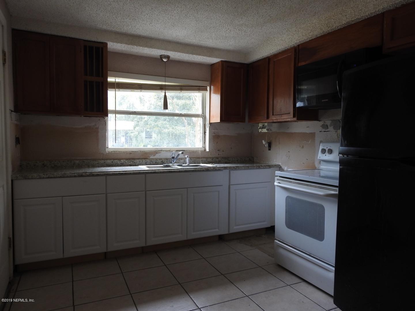 4238 Springwood Road Jacksonville, FL 32207 - Photo 13 of 19 a kitchen with granite countertop white cabinets and white appliances