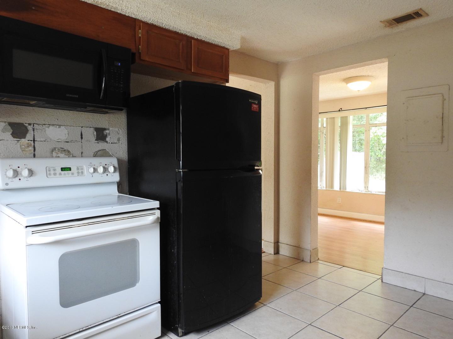 4238 Springwood Road Jacksonville, FL 32207 - Photo 14 of 19 a kitchen with a refrigerator and a stove top oven