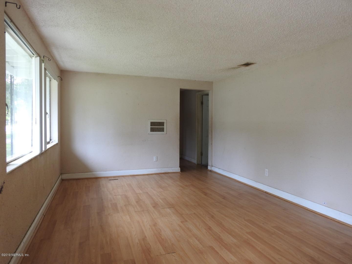 4238 Springwood Road Jacksonville, FL 32207 - Photo 16 of 19 a view of an empty room with wooden floor and a window