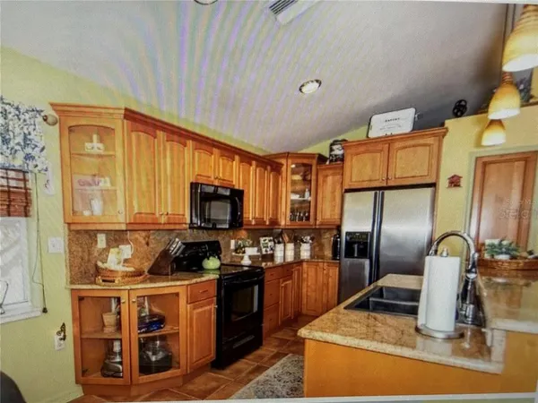 a kitchen with stainless steel appliances granite countertop a stove top oven a sink and a granite counter tops