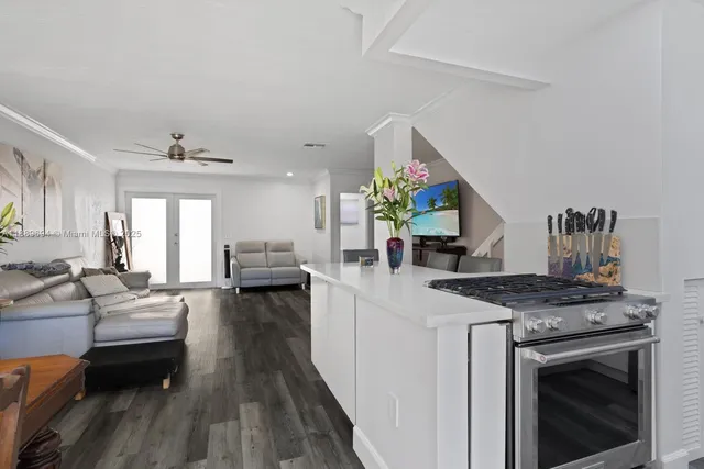 a open kitchen with stainless steel appliances granite countertop a stove a sink dishwasher and cabinets with wooden floor