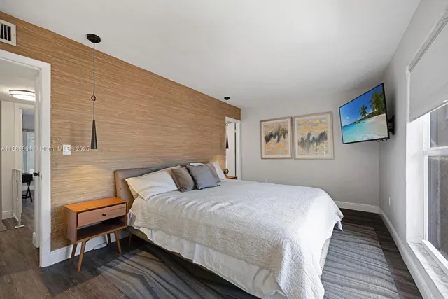 a bedroom with a bed and a painting on the wall