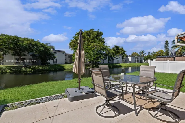a view of a chairs and table in patio next to a yard