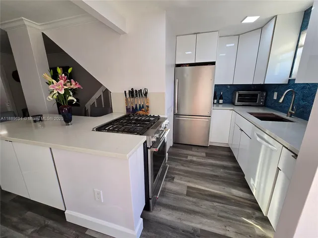 a kitchen with a sink a refrigerator and cabinets
