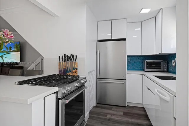 a kitchen with appliances a refrigerator and a stove top oven