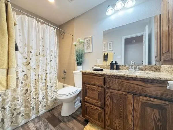 a bathroom with a granite countertop sink a toilet and a mirror