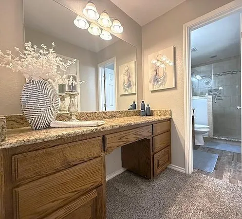 a bathroom with a granite countertop sink a large mirror and a shower