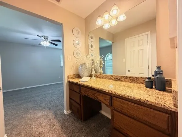 a bathroom with a granite countertop sink and a mirror
