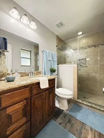 a bathroom with a toilet a sink and glass door