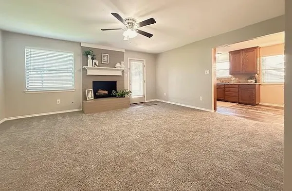 an empty room with windows and fireplace