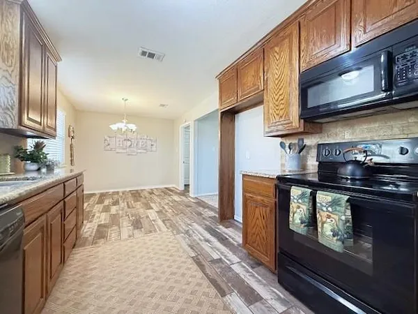 a kitchen with stainless steel appliances granite countertop a stove and cabinets