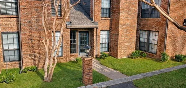 a view of a brick house with a yard