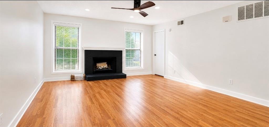 15889 Preston Road, Unit 1004 Dallas, TX 75248 - Photo 4 of 17 a view of an empty room with wooden floor fireplace and a window