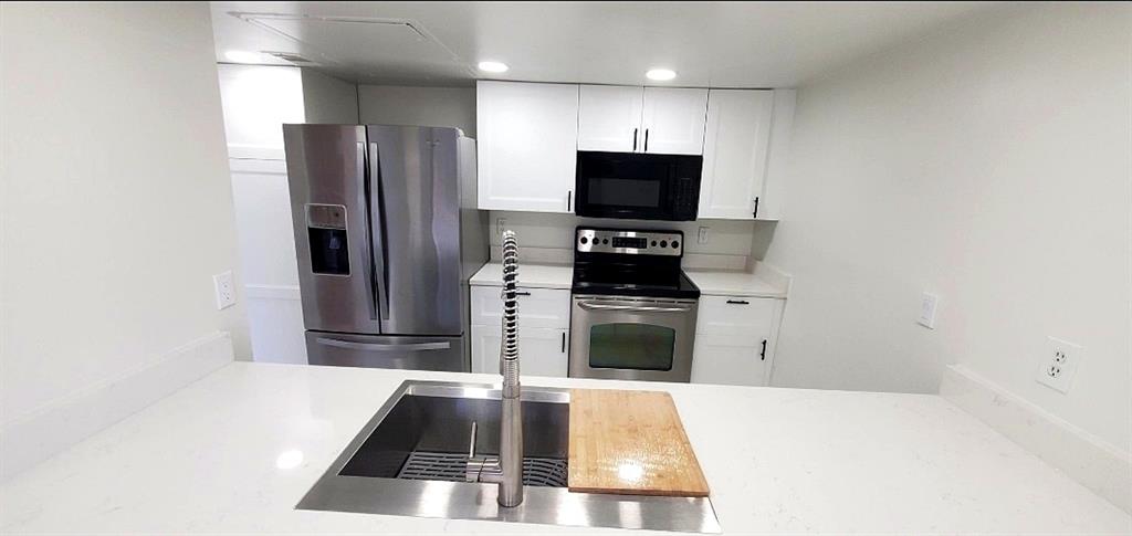 15889 Preston Road, Unit 1004 Dallas, TX 75248 - Photo 6 of 17 a kitchen with granite countertop a refrigerator and a sink