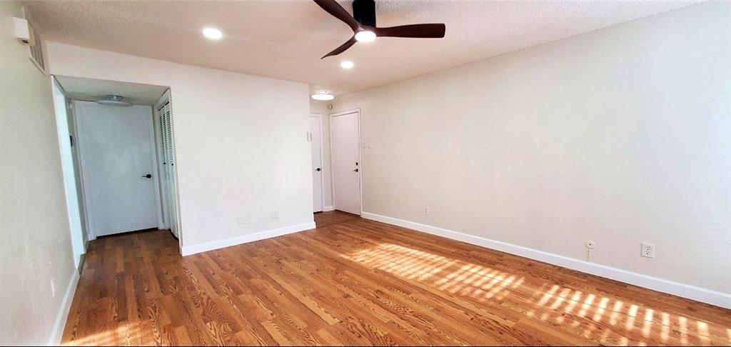 15889 Preston Road, Unit 1004 Dallas, TX 75248 - Photo 9 of 17 an empty room with wooden floor cabinet and windows