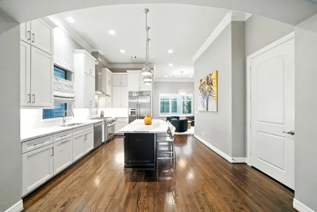 a large white kitchen with lots of counter space a sink appliances and cabinets