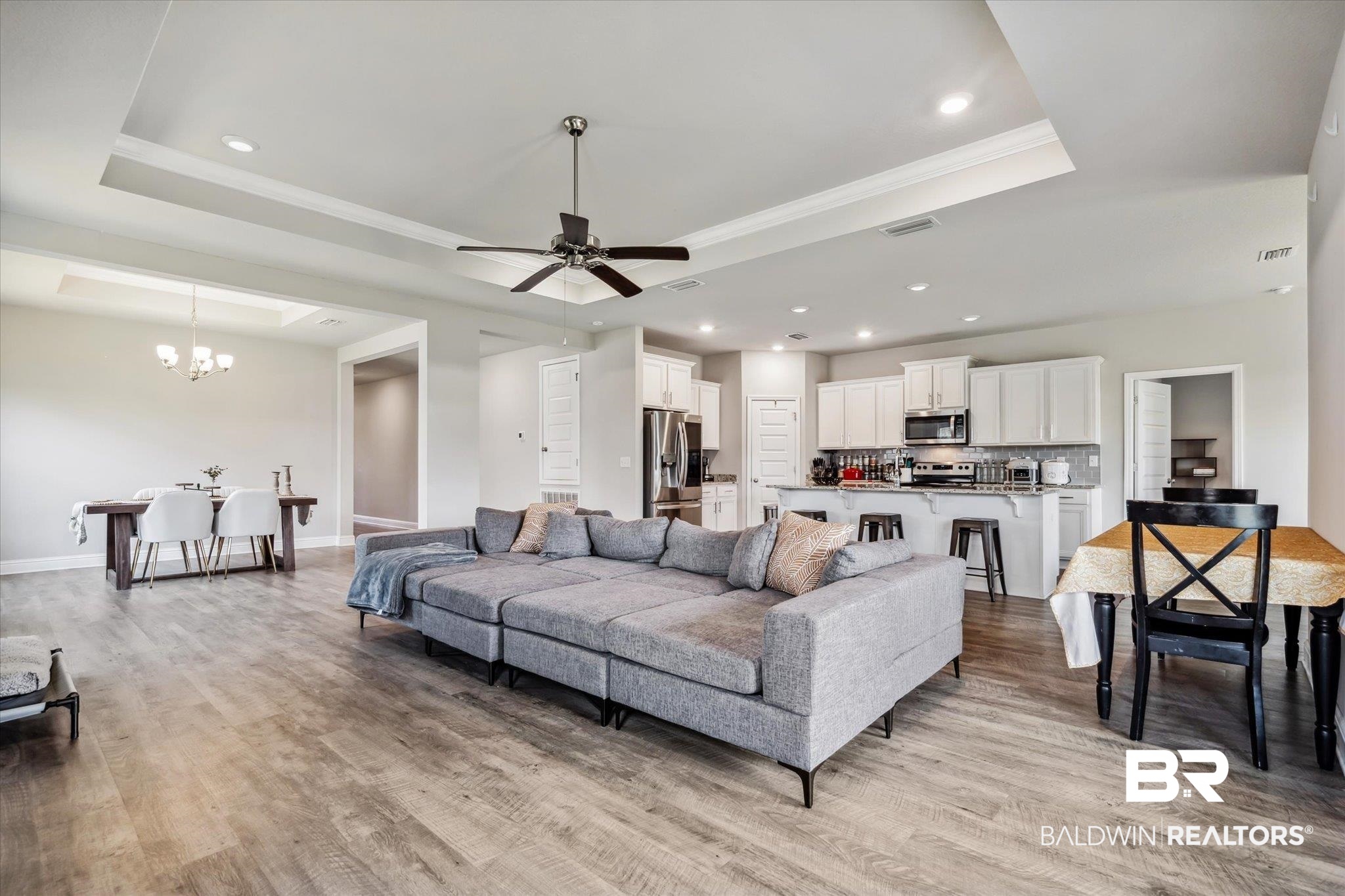 10501 Loamy Avenue Mobile, AL 36695 - Photo 5 of 30 Living room featuring light wood-type flooring, ceiling fan with notable chandelier, and a raised ceiling