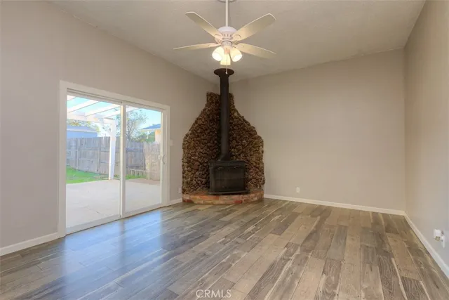 a view of an empty room with glass door and wooden floor