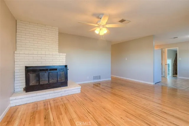 a view of empty room with wooden floor and fireplace