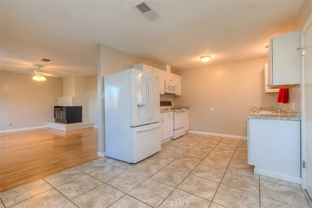 a kitchen with kitchen island granite countertop white cabinets and refrigerator