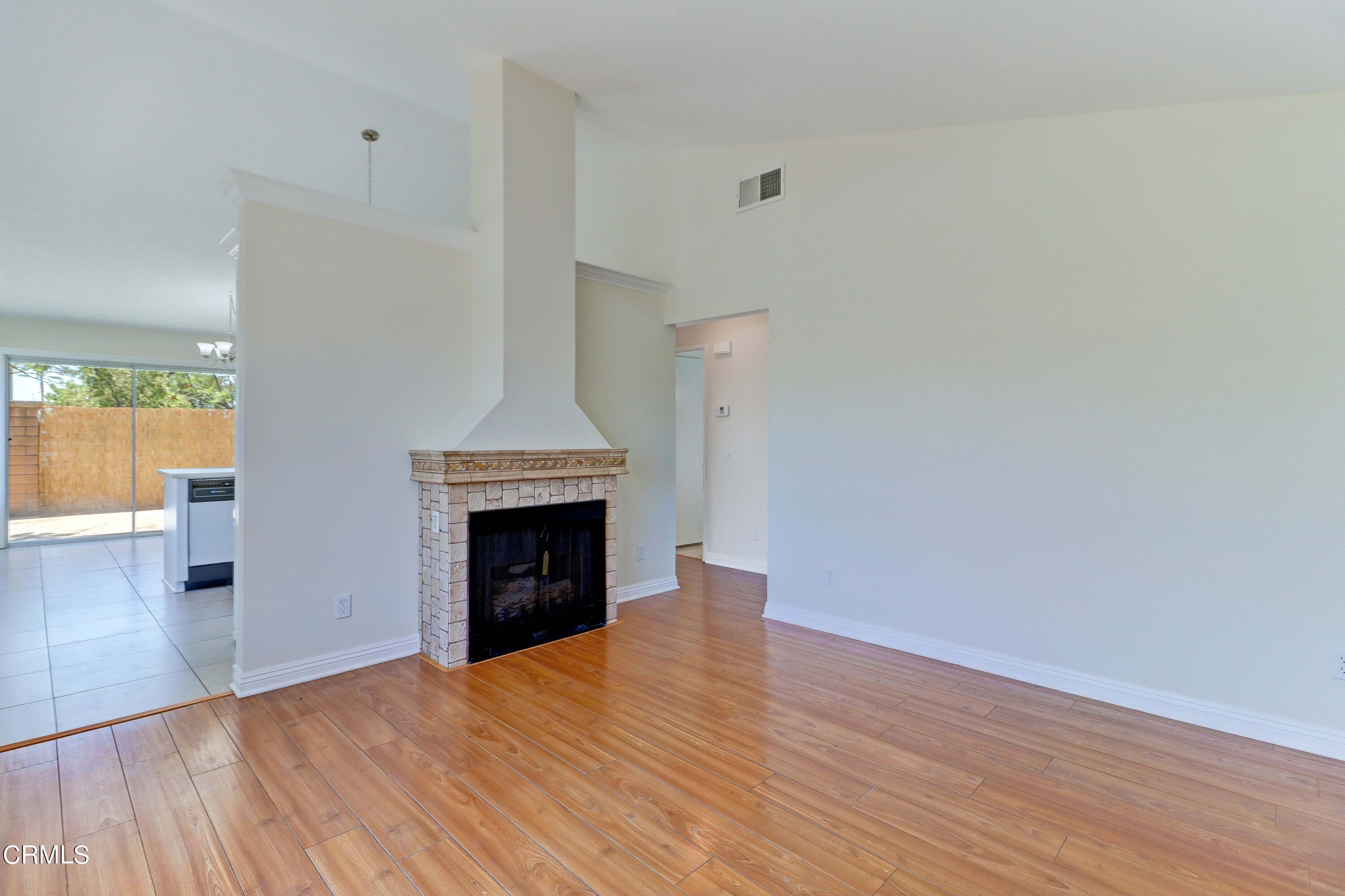 12399 Blazing Star Court Rancho Cucamonga, CA 91739 - Photo 6 of 24 a view of an empty room with wooden floor fireplace and a window