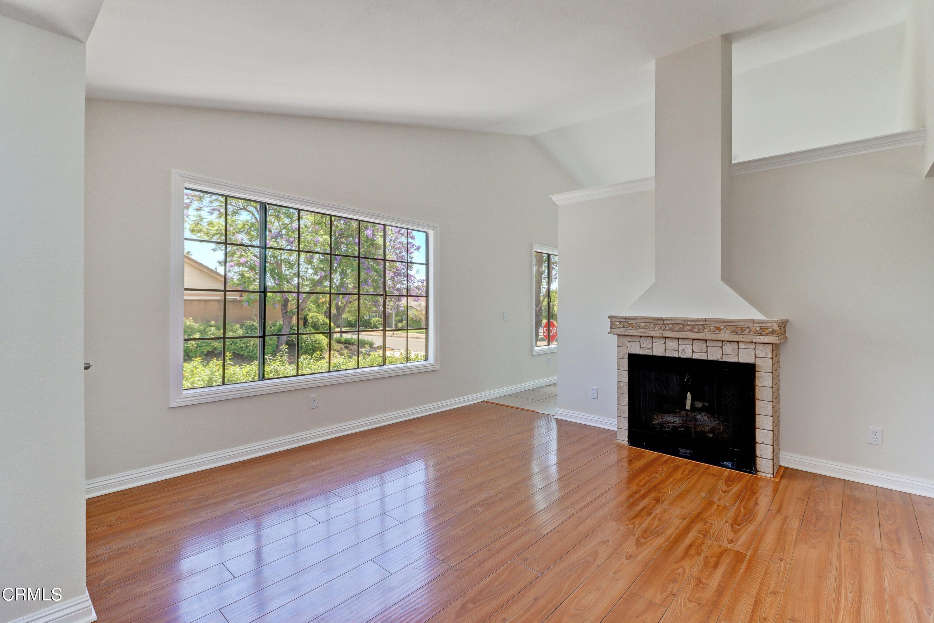 12399 Blazing Star Court Rancho Cucamonga, CA 91739 - Photo 7 of 24 an empty room with wooden floor fireplace and windows